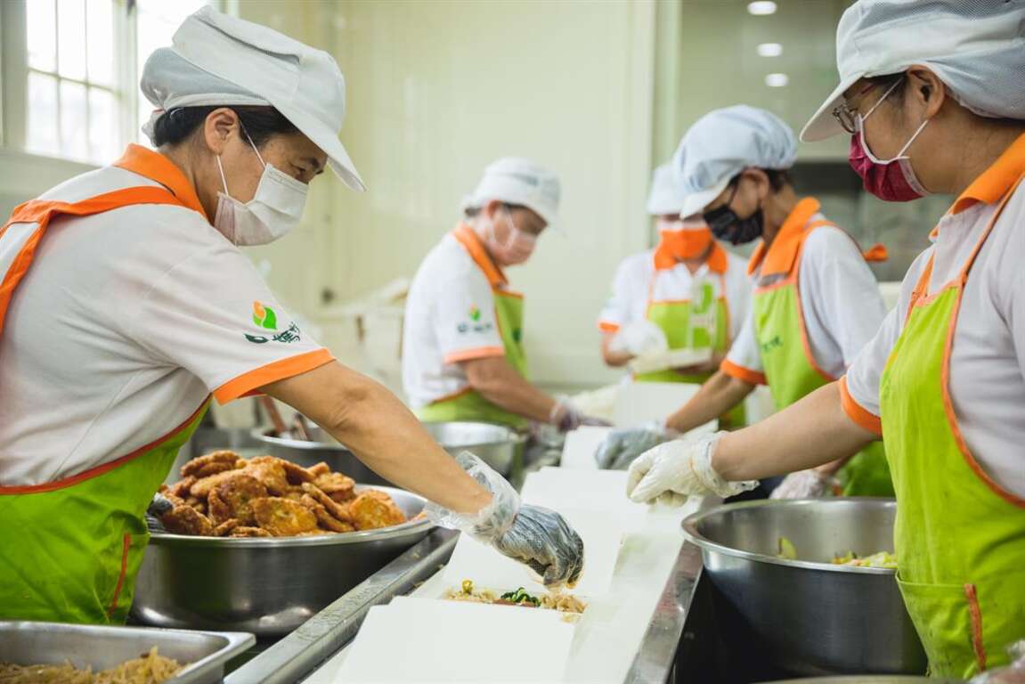 田媽媽們在乾淨明亮衛生的生產線分配食材