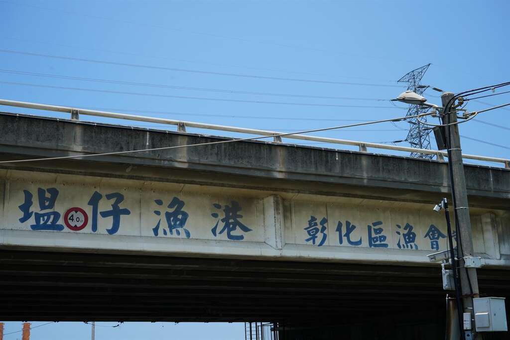 藏身於 61 公路下的塭仔漁港，招牌就寫在高架橋下。