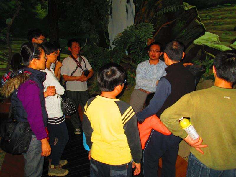 遊客認真聽導覽員對於山林環境的解說。