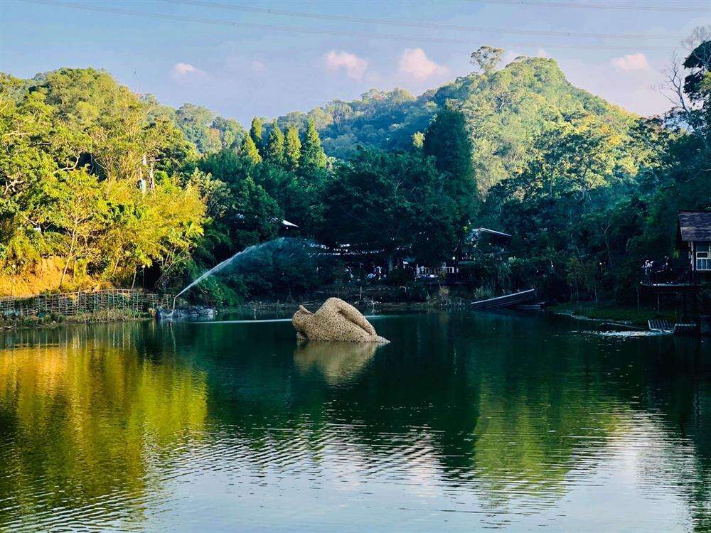 十二寮休閒農業區內的十二寮大埤，湖面的地景裝置藝術沉睡的巨人，週邊圍繞著山林，呈現世外桃源的寧靜感。(圖片來源:十二寮時光村FB)