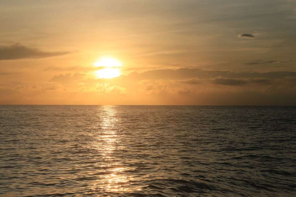 海面上的日出，帶有一些低層的雲慕