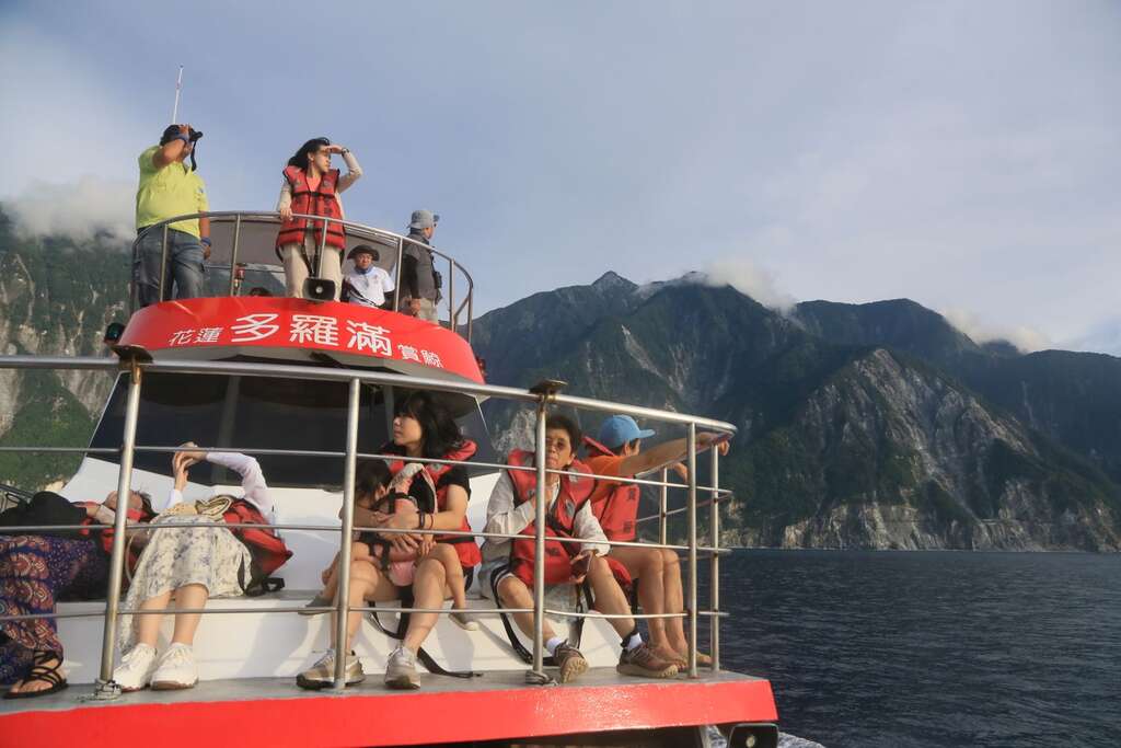 從船頭望向賞鯨船的高層甲板，工作人員拿著望遠鏡觀察周圍