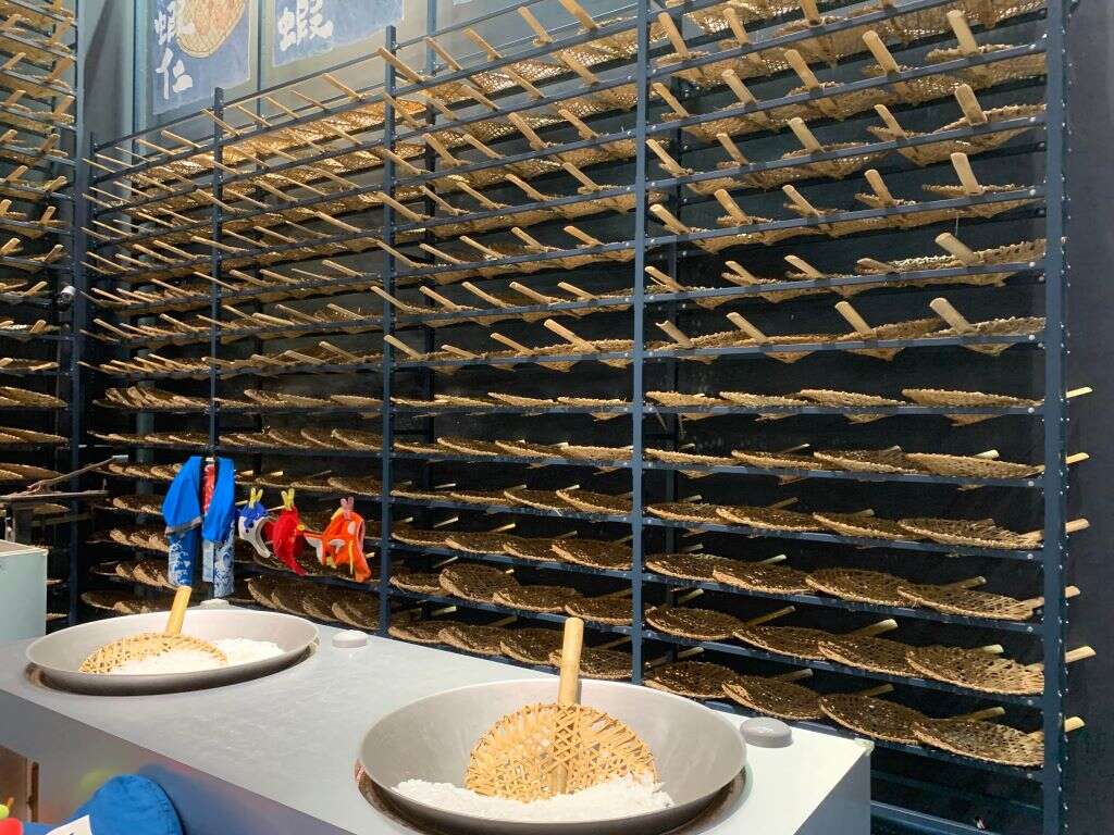 漁撈廚房體驗區：可拿起竹編的大飯籬，體驗撈起小魚們的樂趣，後方牆面有擺放整面的飯籬，模擬傳統晾乾水產品的壯觀畫面