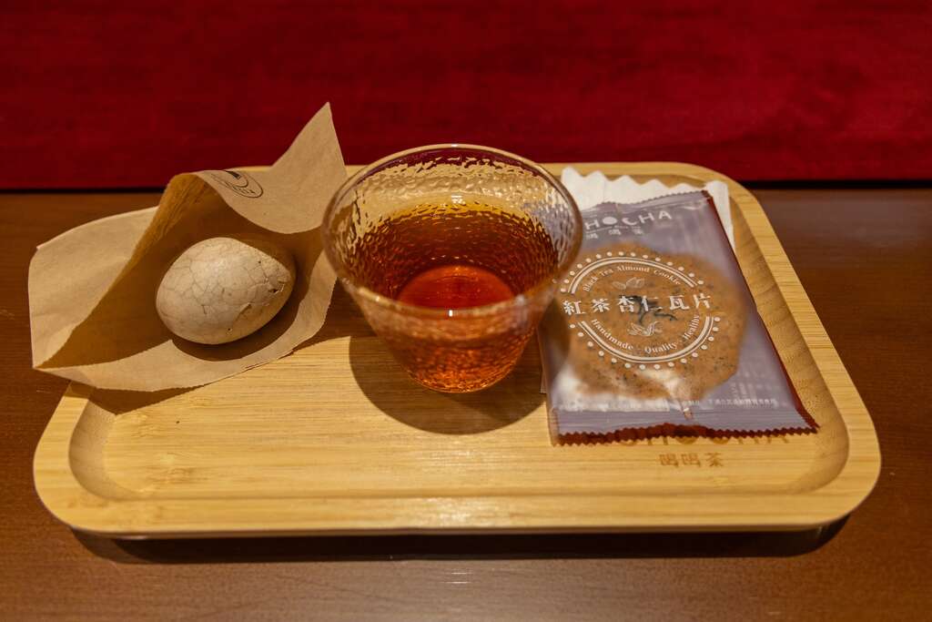 照片中有一個木製的托盤，裏頭有Hohocha喝喝茶觀光工廠招待遊客的茶葉蛋、紅茶與杏仁瓦片餅乾