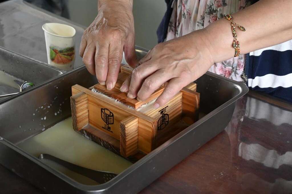 蓋上豆腐模,把多餘的水分擠出。