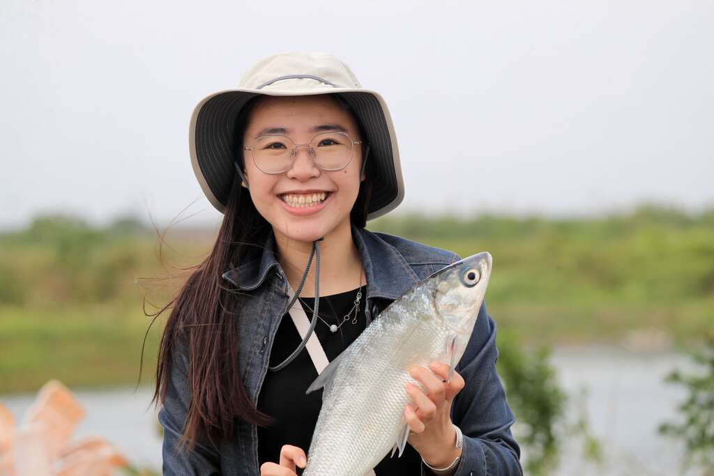 長盈海味屋第三代謝佳歆與剛從流刺網取下的虱目魚